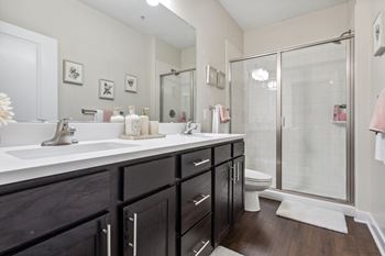 A bathroom with a white sink and a glass shower stall.at Century Hampton Roads, Suffolk Virginia  
